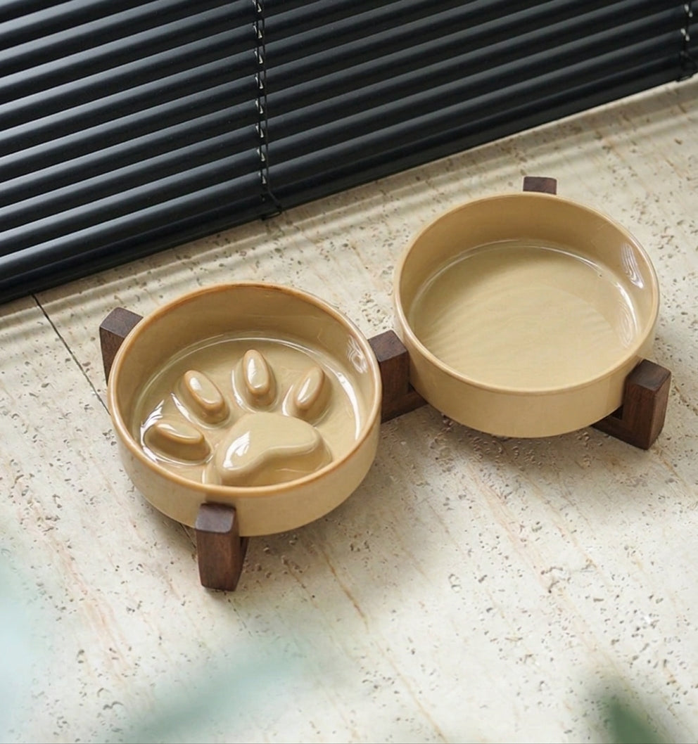 Luxe keramische voederbak set met donker hout op een lichte natuurstenen tegelvloer bij een raam met zwarte jaloezieën